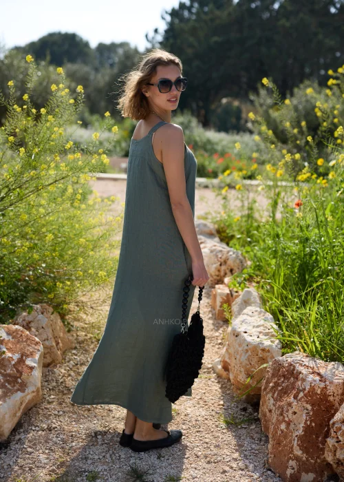 Oliwkowa lniana sukienka maxi na szerokich ramiączkach o luźnym, minimalistycznym kroju. Naturalna tkanina i swobodny fason tworzą ponadczasową stylizację w stylu boho i slow fashion.