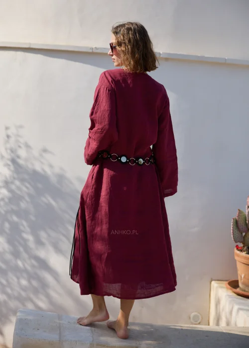 Bordowa lniana sukienka midi z dekoltem V i długimi rękawami o luźnym, naturalnym fasonie. Minimalistyczny krój podkreśla elegancję stylizacji w klimacie boho i slow fashion.