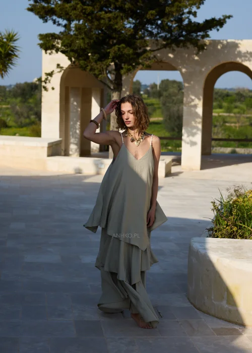 Oliwkowa sukienka maxi na cienkich ramiączkach z warstwowymi falbanami i luźnym, zwiewnym fasonem. Kobiecy model w stylu boho, idealny na wakacyjne stylizacje, spacery i letnie przyjęcia.