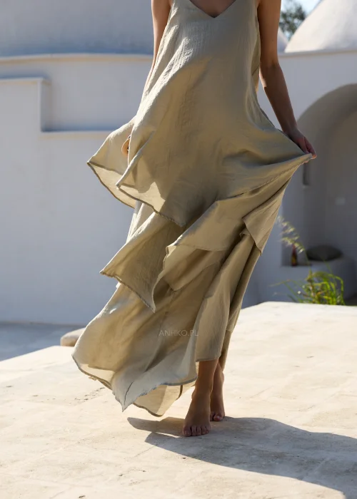 Oliwkowa sukienka maxi na cienkich ramiączkach z warstwowymi falbanami i luźnym, zwiewnym fasonem. Kobiecy model w stylu boho, idealny na wakacyjne stylizacje, spacery i letnie przyjęcia.
