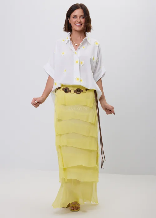 Biała koszula damska z dekoracyjnymi aplikacjami w kształcie stokrotek, krótkim podwiniętym rękawem i klasycznym kołnierzykiem. Luźny model w stylu boho, idealny do letnich stylizacji ze spódnicami i lekkimi spodniami.