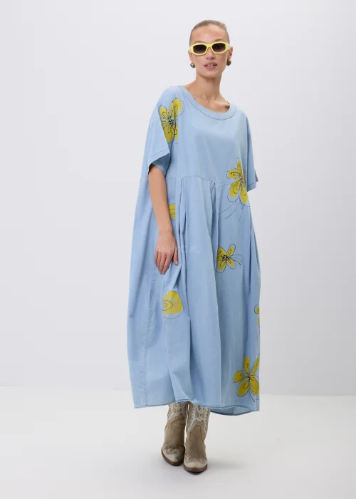Błękitna sukienka maxi oversize z krótkim rękawem i efektownym nadrukiem dużych żółtych kwiatów. Luźny fason z odcięciem pod biustem zapewnia swobodę noszenia i tworzy lekką, kobiecą stylizację na co dzień.