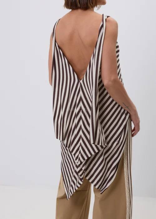 Damski top bez rękawów w beżowo-brązowe paski o luźnym, asymetrycznym fasonie. Modna stylizacja casual ze spodniami w kolorze camel z ozdobnym koronkowym lampasem, inspirowana naturalną elegancją.