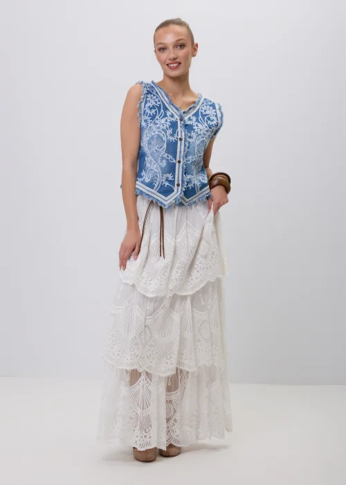 Biała koronkowa spódnica maxi w stylu boho z warstwowymi falbanami, ażurowymi haftami i ozdobnym brązowym paskiem w talii. Romantyczny model o efektownym wykończeniu, idealny do letnich i eleganckich stylizacji.