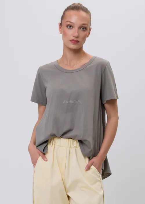 Szary damski T-shirt oversize o luźnym, lekko rozkloszowanym fasonie z krótkim rękawem i okrągłym dekoltem. Minimalistyczna bluzka basic w stonowanym odcieniu, zestawiona z jasnymi spodniami w eleganckiej codziennej stylizacji.