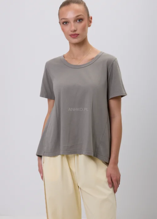 Szary damski T-shirt oversize o luźnym, lekko rozkloszowanym fasonie z krótkim rękawem i okrągłym dekoltem. Minimalistyczna bluzka basic w stonowanym odcieniu, zestawiona z jasnymi spodniami w eleganckiej codziennej stylizacji.