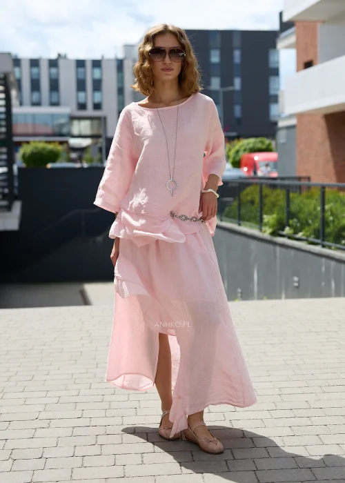 Pudroworóżowa lniana bluzka damska z rękawem 3/4, asymetrycznymi falbanami i luźnym fasonem oversize, prezentowana w eleganckiej miejskiej stylizacji.
