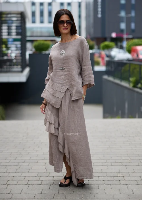 Lniana bluzka oversize w odcieniu taupe z rękawem 3/4 i asymetrycznym wykończeniem z dekoracyjnymi warstwowymi zakładkami z przodu.