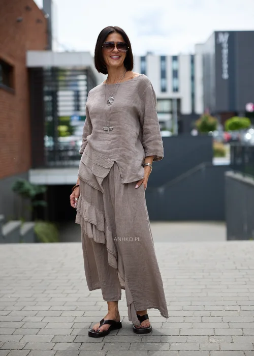 Lniana bluzka oversize w odcieniu taupe z rękawem 3/4 i asymetrycznym wykończeniem z dekoracyjnymi warstwowymi zakładkami z przodu.