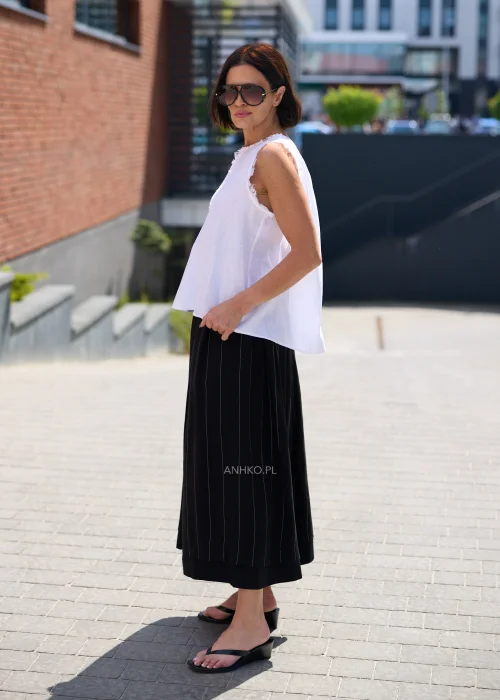 Czarna spódnica maxi z delikatnymi pionowymi prążkami i elastyczną talią, zwiewny fason w eleganckiej minimalistycznej stylizacji.