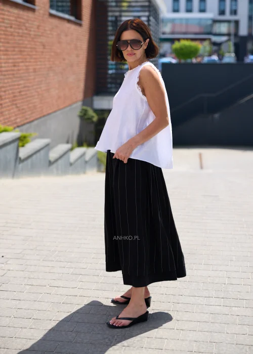 Czarna spódnica maxi z delikatnymi pionowymi prążkami i elastyczną talią, zwiewny fason w eleganckiej minimalistycznej stylizacji.