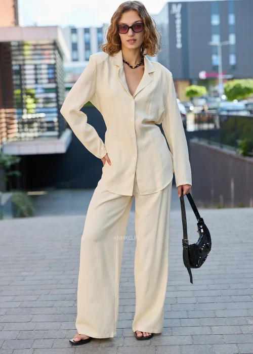 Damski elegancki komplet w kolorze ecru z marynarką zapinaną na guziki i szerokimi spodniami, idealny do nowoczesnych stylizacji casualowych i smart casual