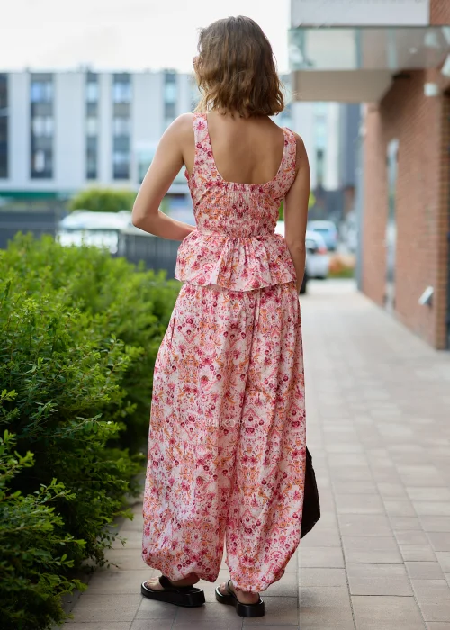 Top z szerokimi ramiączkami o dopasowanej górze i kobiecym fasonie z falbaną peplum. Model posiada szeroki, zaokrąglony dekolt oraz efektowny kwiatowo-orientalny print w odcieniach pudrowego różu, koralu